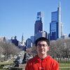 Ethan Chen smiling in a park in the city 