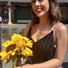 A women smiling holding yellow flowers