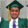 A male graduate in a green cap and gown