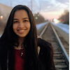 A female smiling on railroad tracks