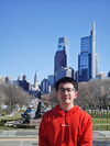 Ethan Chen smiling in a park in the city 