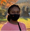A young lady smiling with a mask on , in front of Aluma Molter
