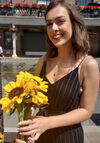 A women smiling holding yellow flowers