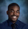 A young man smiling in front of blue black drop