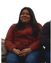 A f\women in a red-brownisg skirt and jeans sitting in a bench