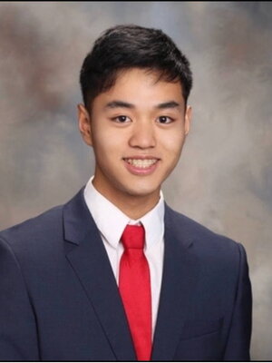 A young man in a suit smiling