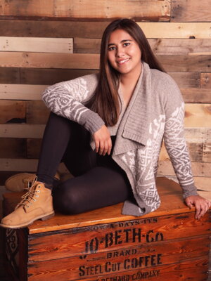 A young lady posing on a wooden crate