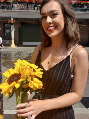 A women smiling holding yellow flowers