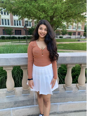 A female college student in white skirt and pink shirt