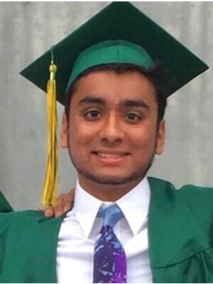 A male graduate in a green cap and gown