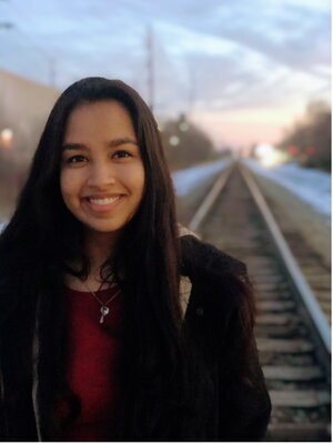 A female smiling on railroad tracks