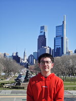 Ethan Chen smiling in a park in the city 