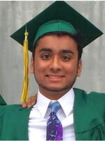 A male graduate in a green cap and gown