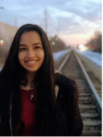 A female smiling on railroad tracks